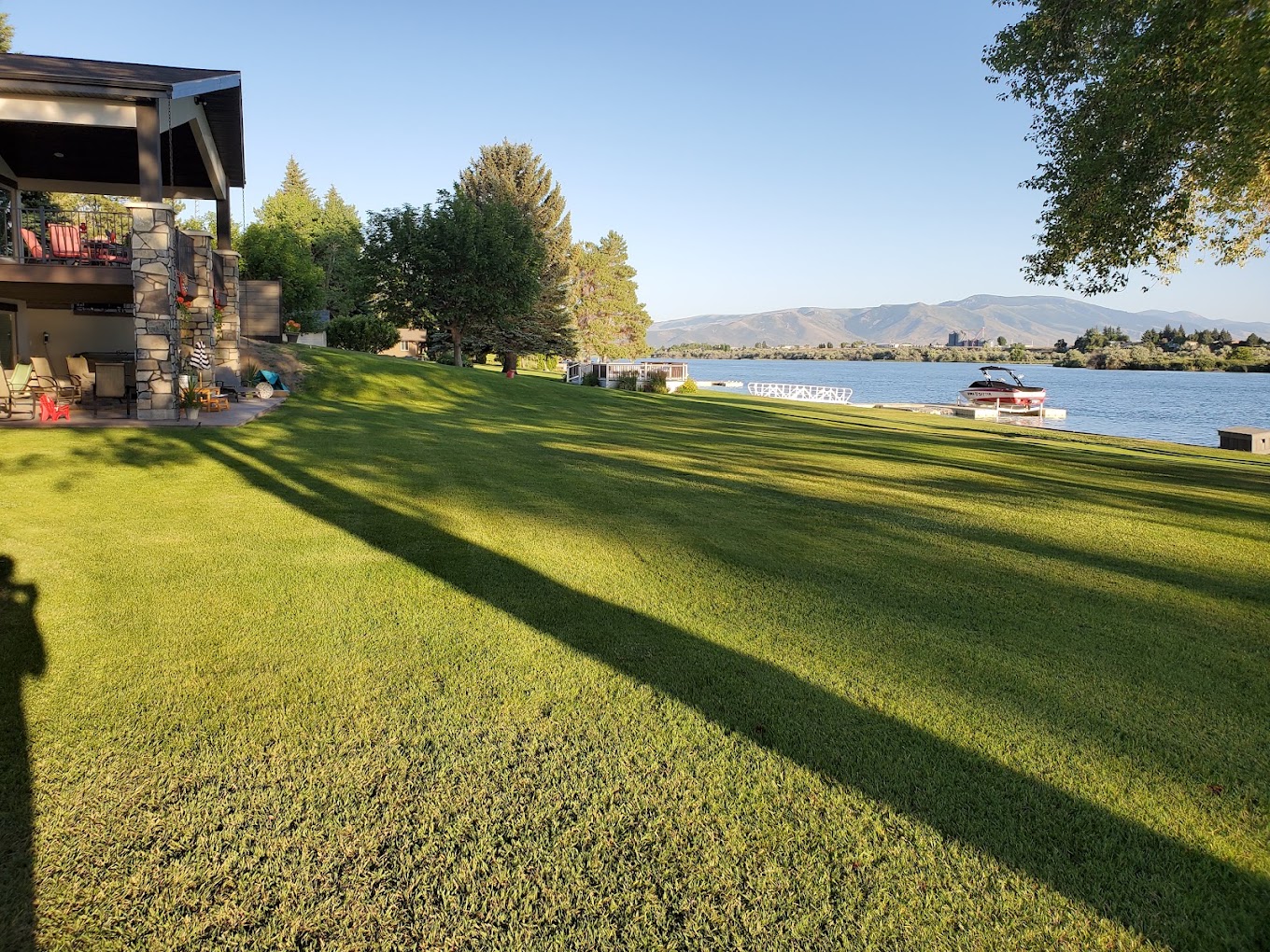 Lakefront property with lush green maintained lawn