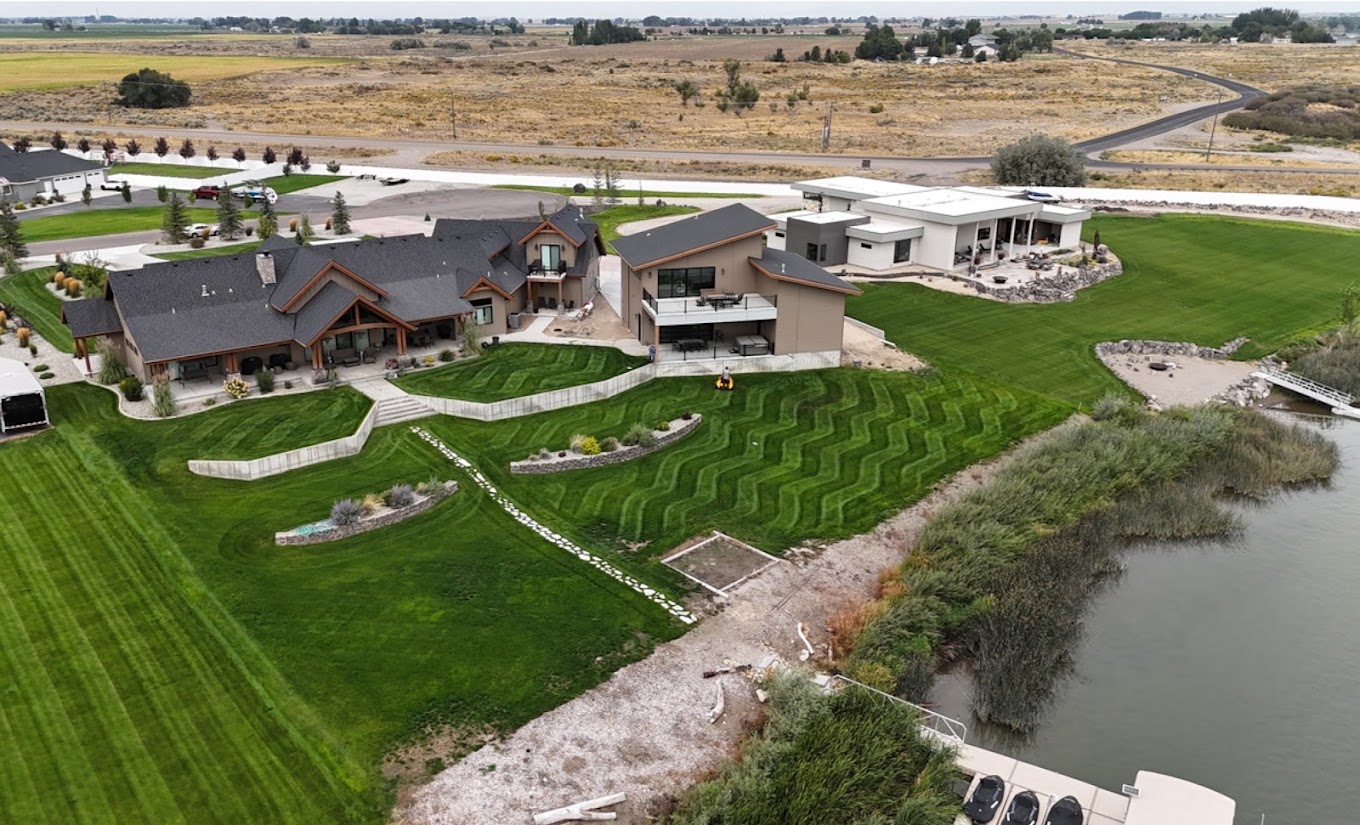 Aerial view of a riverfront estate with patterned mowed lawn
