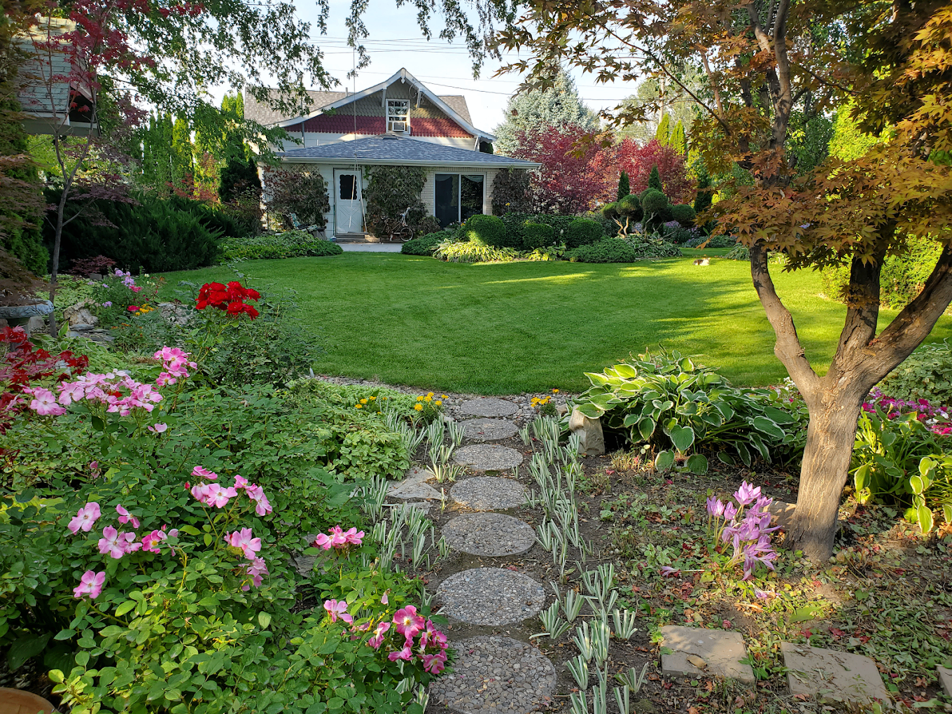 Lush manicured lawn and garden with stone pathway
